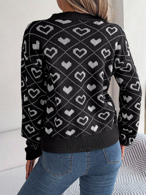 Black acrylic knit sweater with allover white heart jacquard pattern and V-neck.