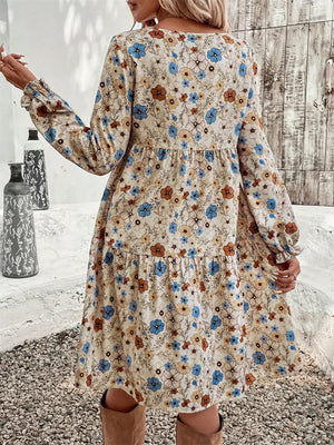 Floral tiered hem long sleeve dress with blue, brown, and tan flowers on cream.