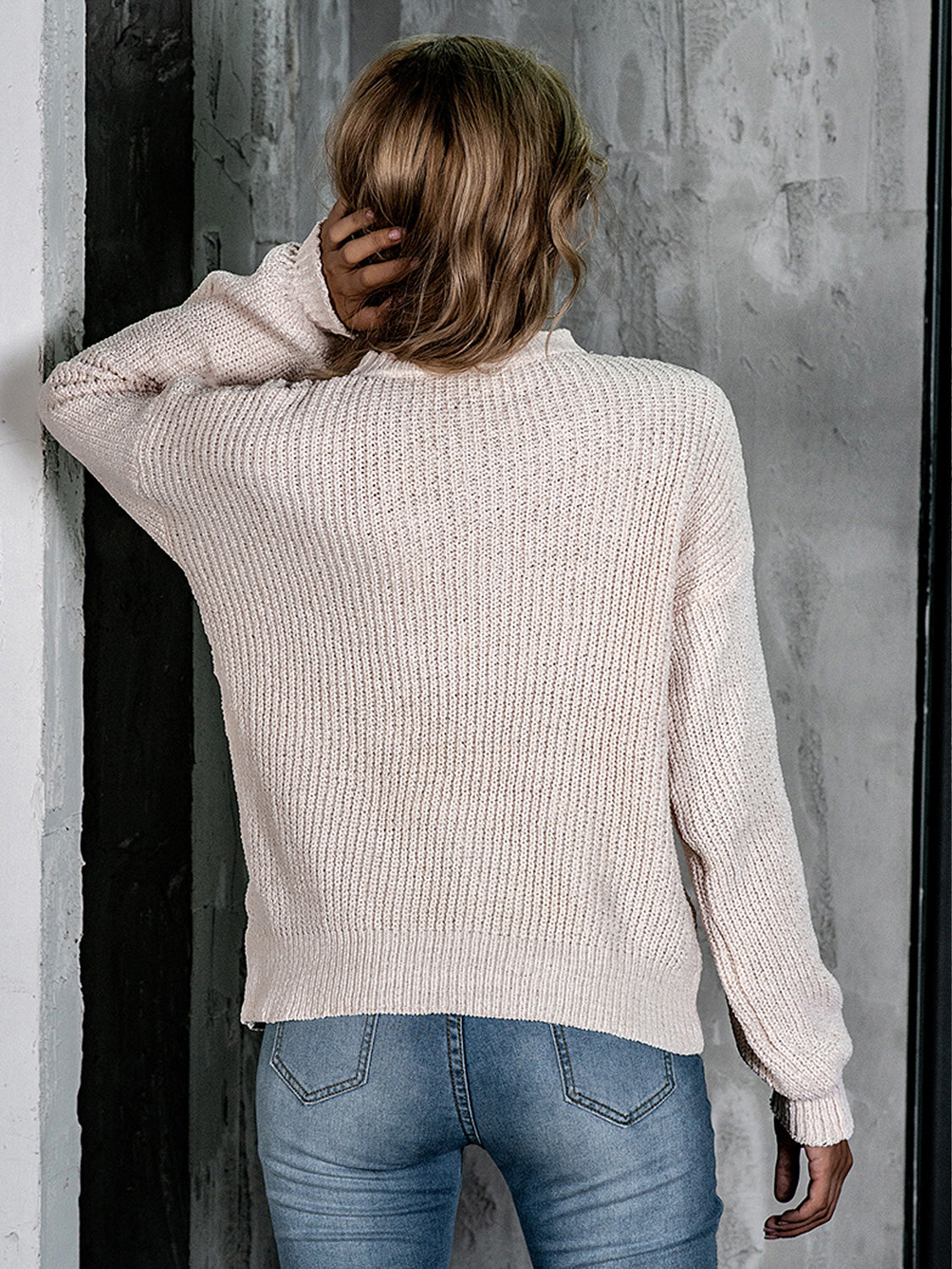 Openwork knit crew neck pullover in blush pink with balloon sleeves.