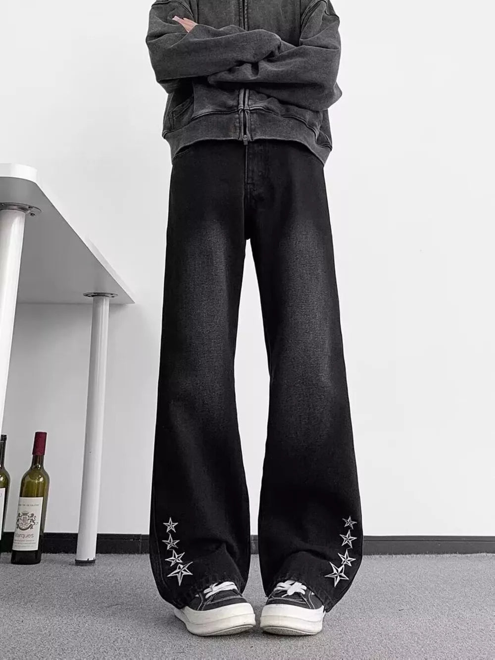 Men's black wide-leg jeans with star embellishments on the cuffs, made of 100% cotton.