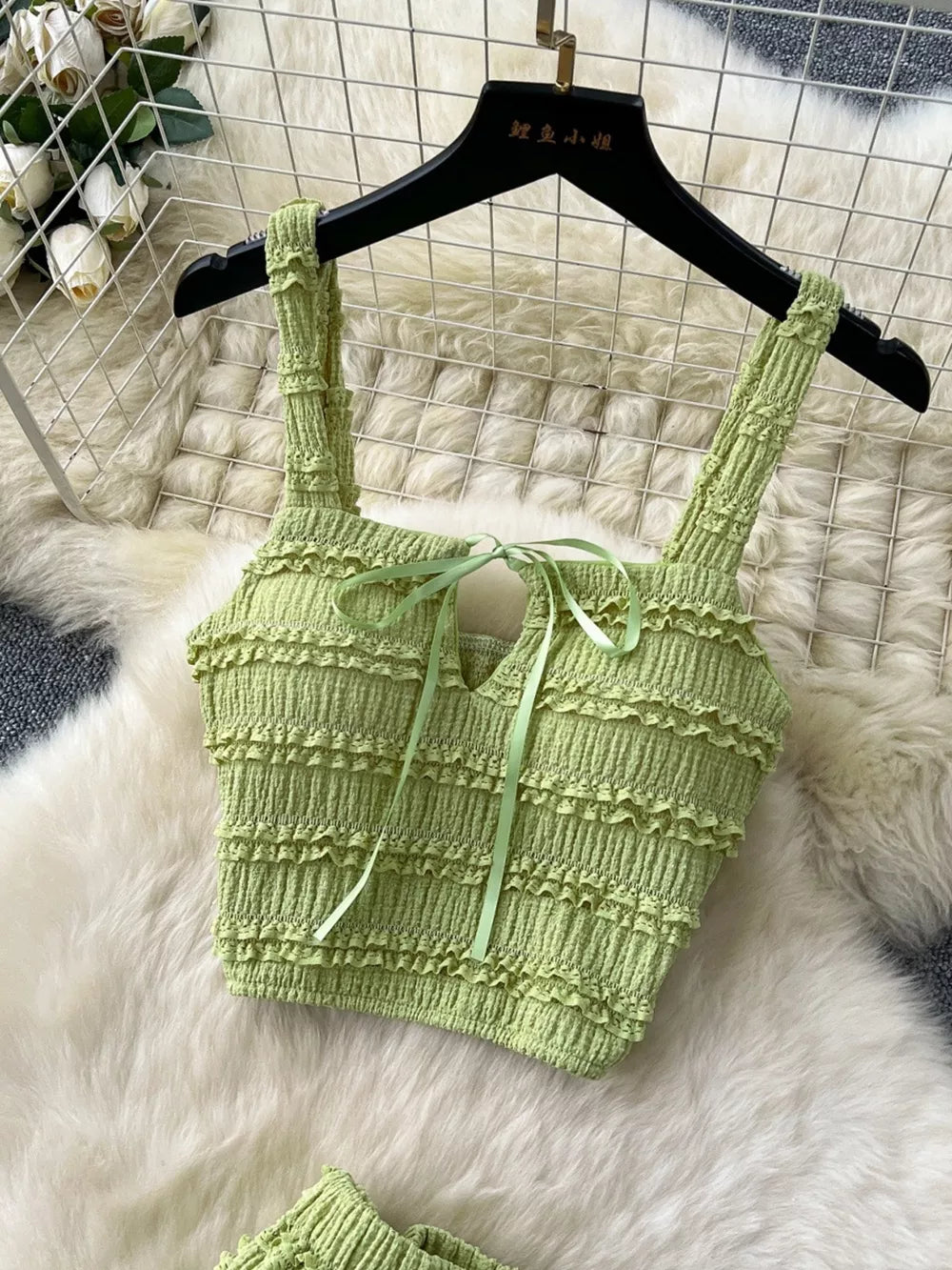 Green ruched crop top with tie detail and frill trim.