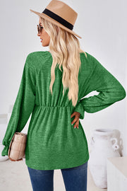 Green long sleeve blouse with cinched waist and balloon sleeves.