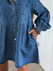 Blue denim mini dress with pockets, button front, and smocked cuffs.
