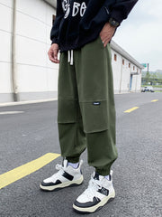Men's army green relaxed fit joggers with drawstring and patch detail.