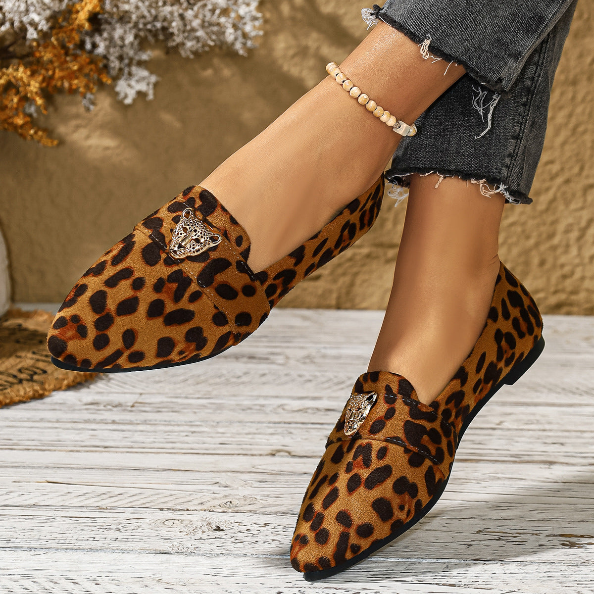 Point toe slip-on flats with leopard print and silver tiger head detail.