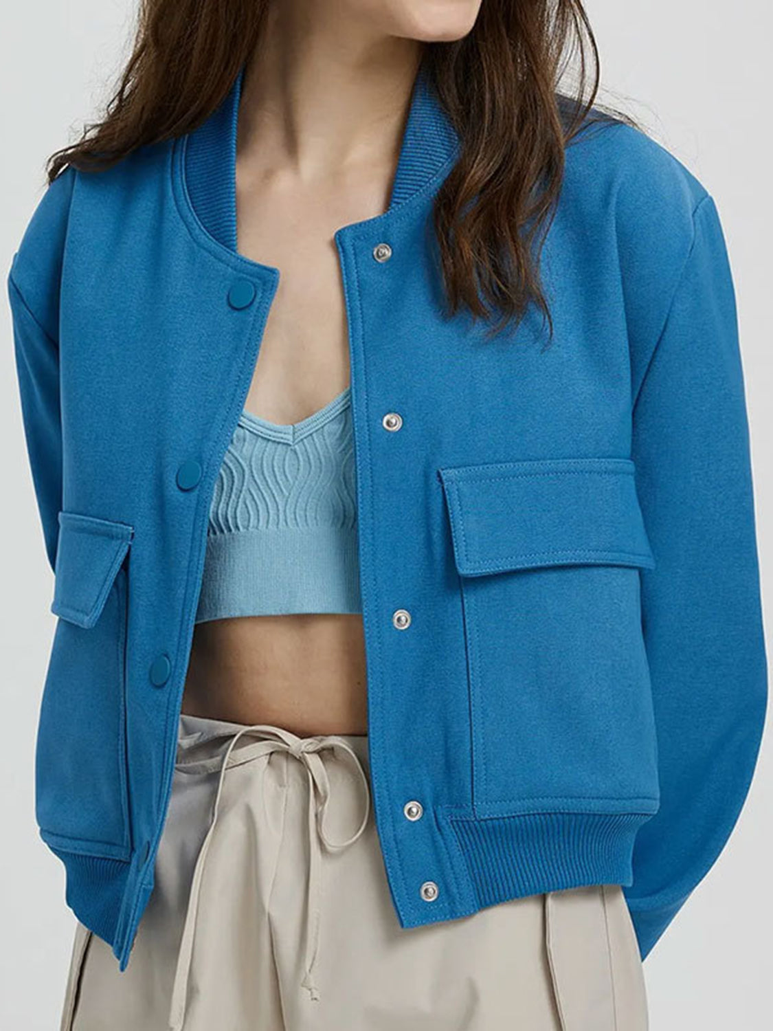 Boxy bomber jacket in Sky Blue with snap front, ribbed collar, and two chest pockets.