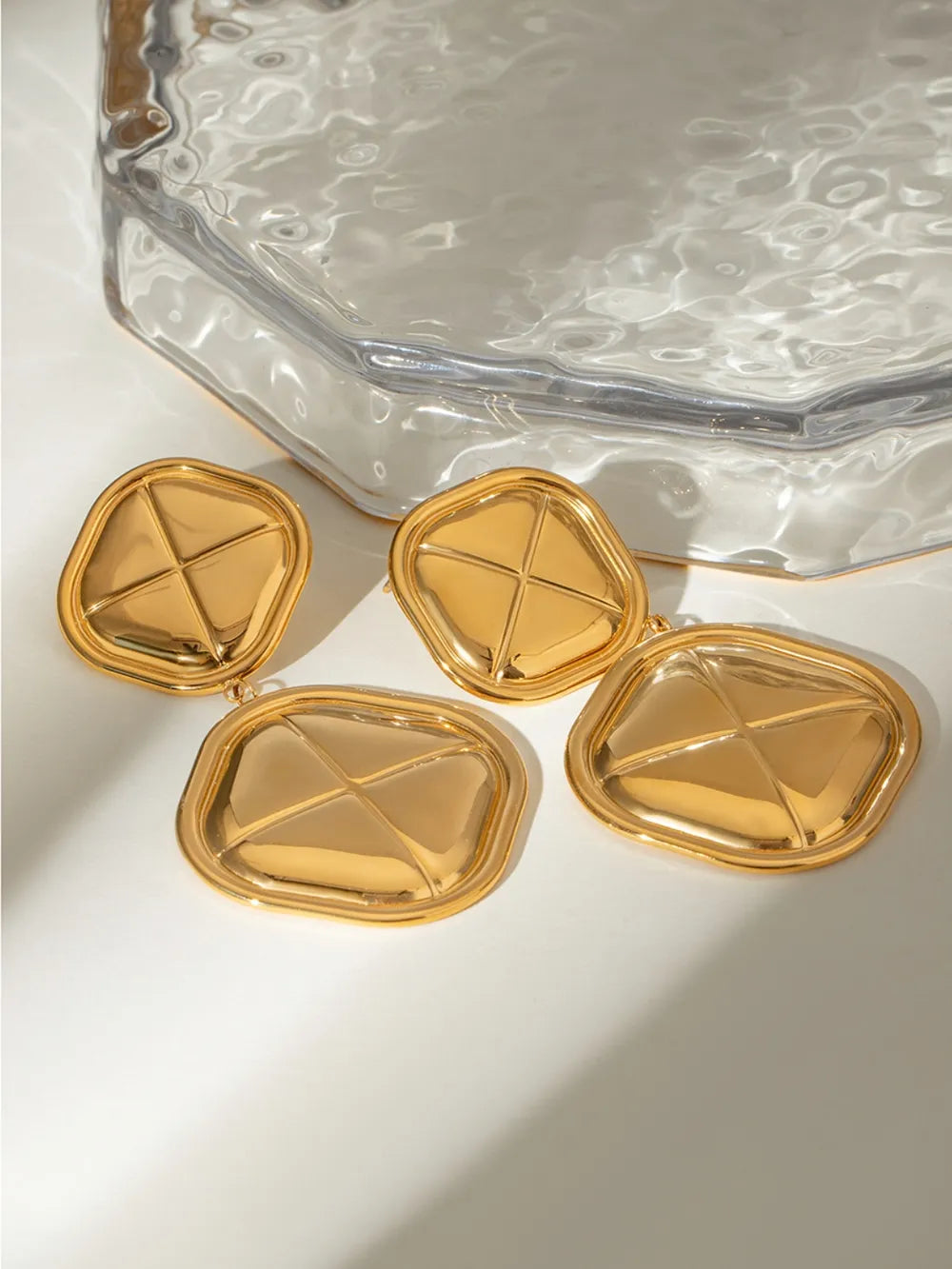 Sculpted geo drop earrings in gold-plated metal with a geometric pattern.