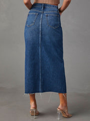 Denim midi skirt in dark wash with raw hem and buttoned closure.