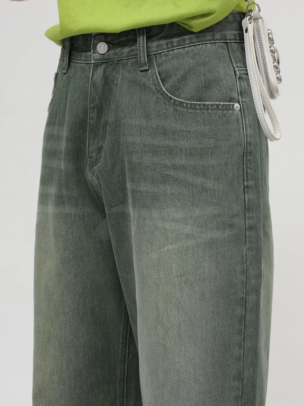 Faded olive wide leg denim jeans with a relaxed fit and visible pocket details.