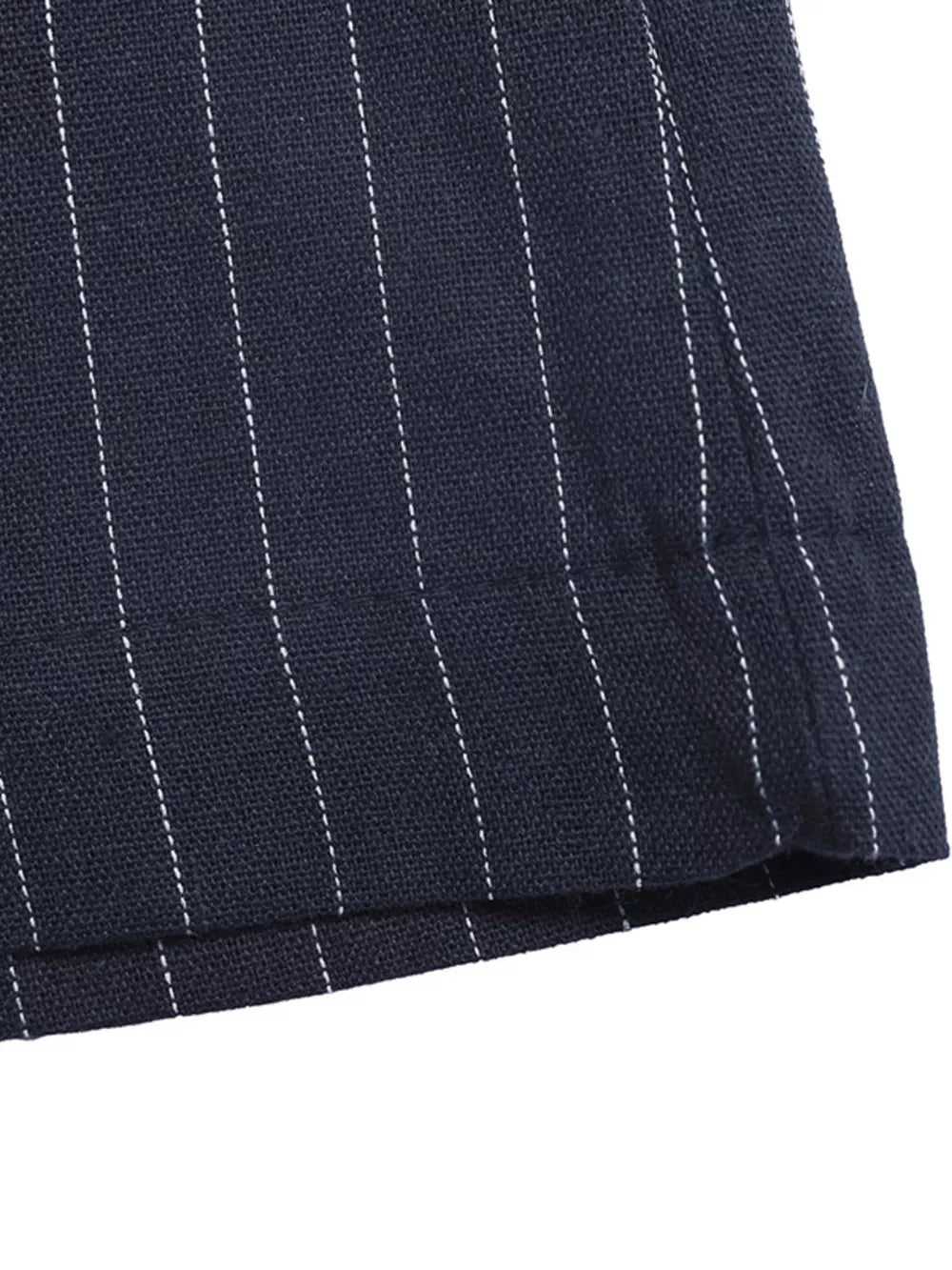Navy pinstripe cotton maternity jumpsuit detail showing hem and stitching.