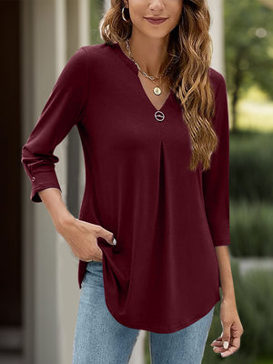 Burgundy pleated V-neck three-quarter sleeve top with a decorative button detail.