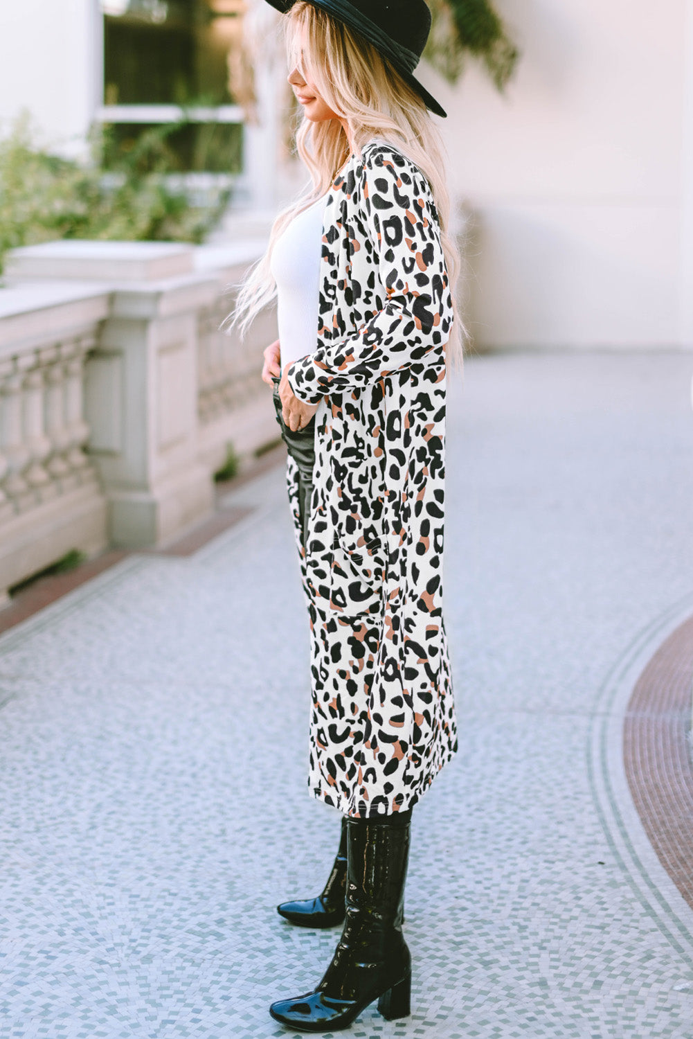 Leopard print duster cardigan with long sleeves and an open front, styled with a white top and black boots.