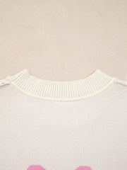 Beige acrylic blend sweater with pink bow print and ribbed crew neck.