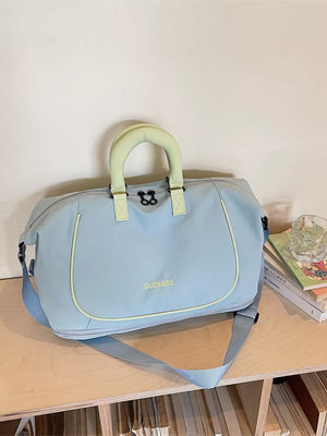 Light blue Oxford cloth duffle bag with chartreuse handles and trim, and a detachable shoulder strap.