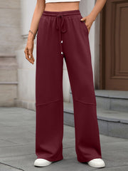 Wine Red high-waist drawstring wide-leg pants with pockets and paneled detail.