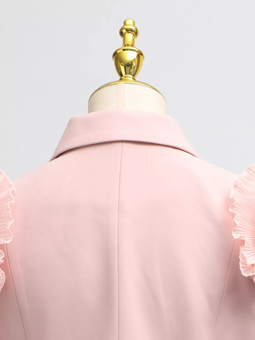 Pink skirt suit with elegant frill collar and balloon sleeves.