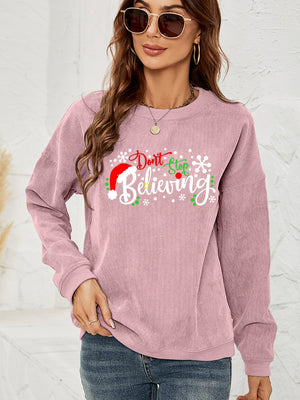 Dusty Pink corduroy crewneck sweatshirt with "Don't Stop Believing" Christmas graphic and snowflakes.