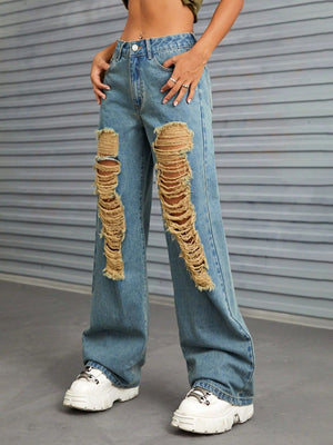 Medium wash denim jeans with large distressed rips and raw edge detail