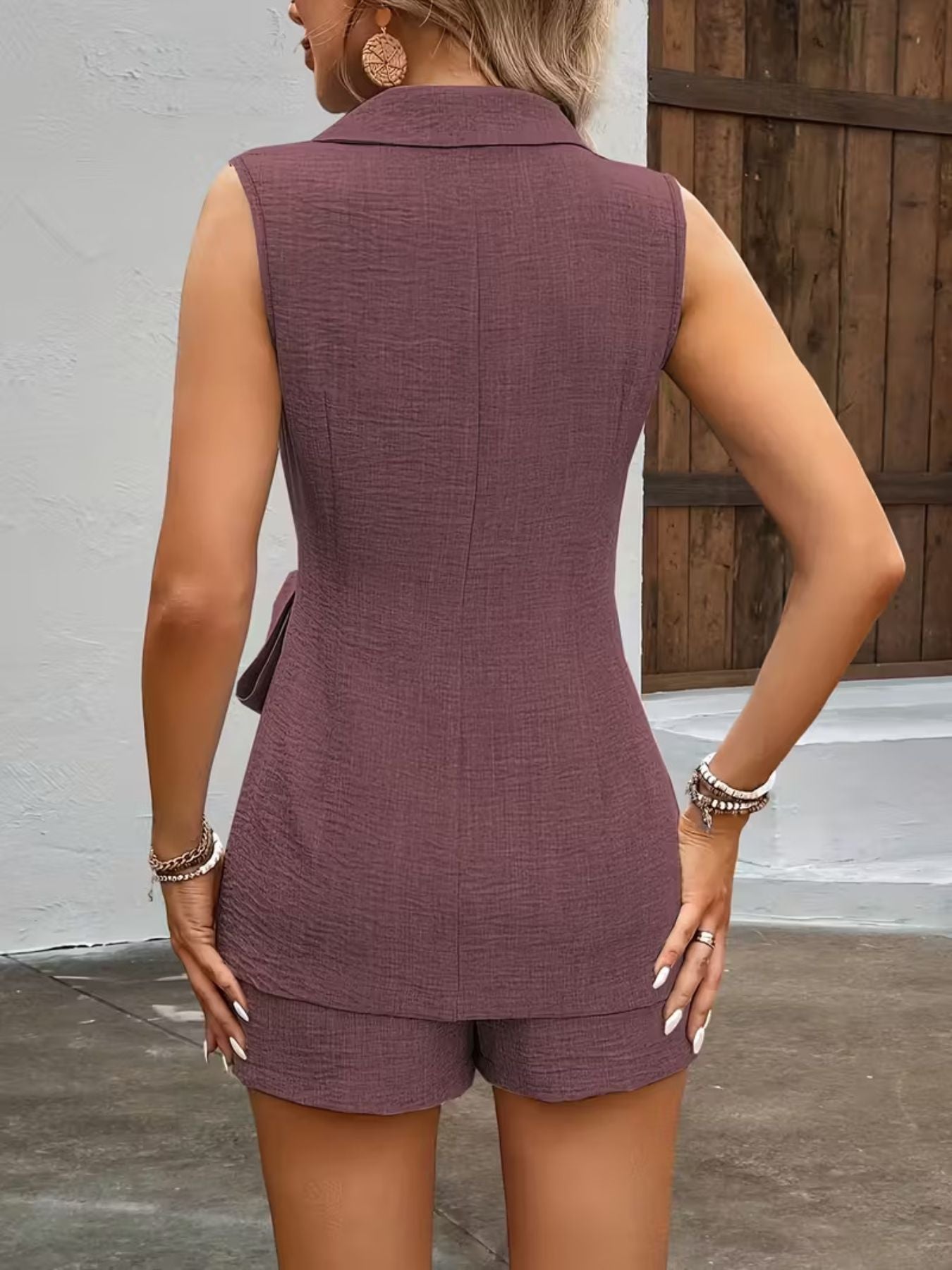 Sleeveless blazer and tailored shorts set in mauve with textured fabric and a tie detail.