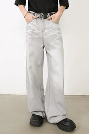 Bleached wash wide-leg denim trousers in gray with a unique abstract pattern.