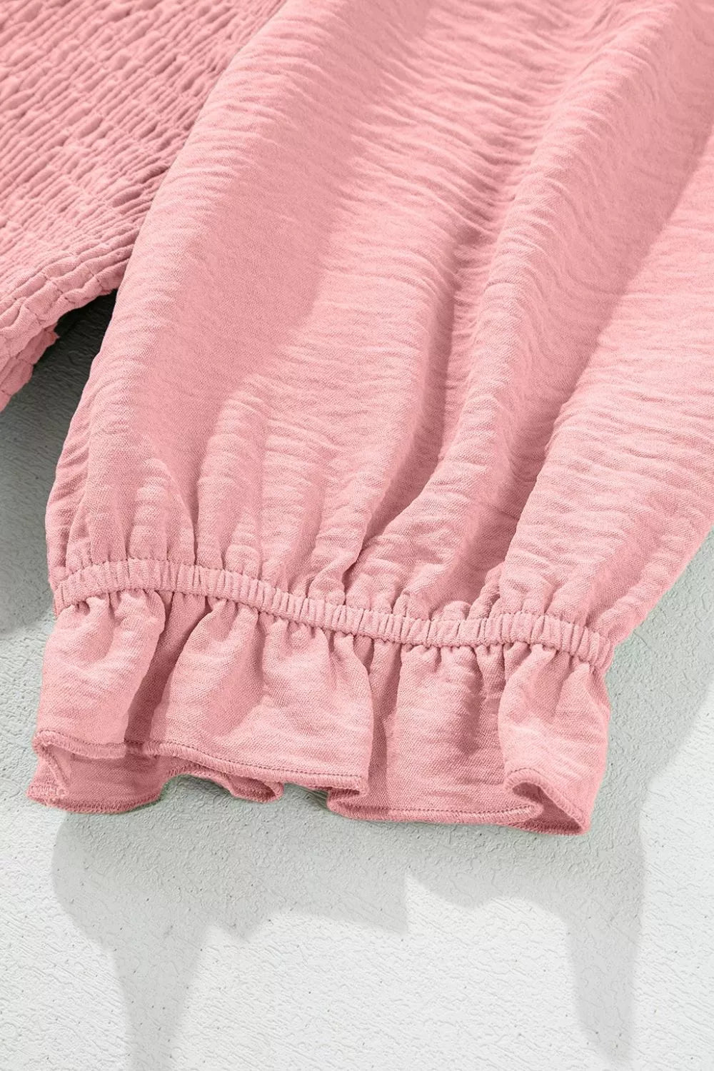 Dusty pink smocked mini dress with frilled hem and cuffs