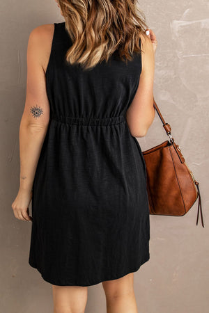 Black button-down mini dress with gathered waistline and sleeveless cut.