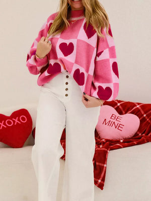 Pink and red checkered heart knit sweater with a relaxed fit and crew neck.