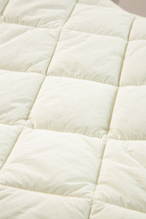 Ivory quilted stand collar vest detail showing diamond pattern stitching.