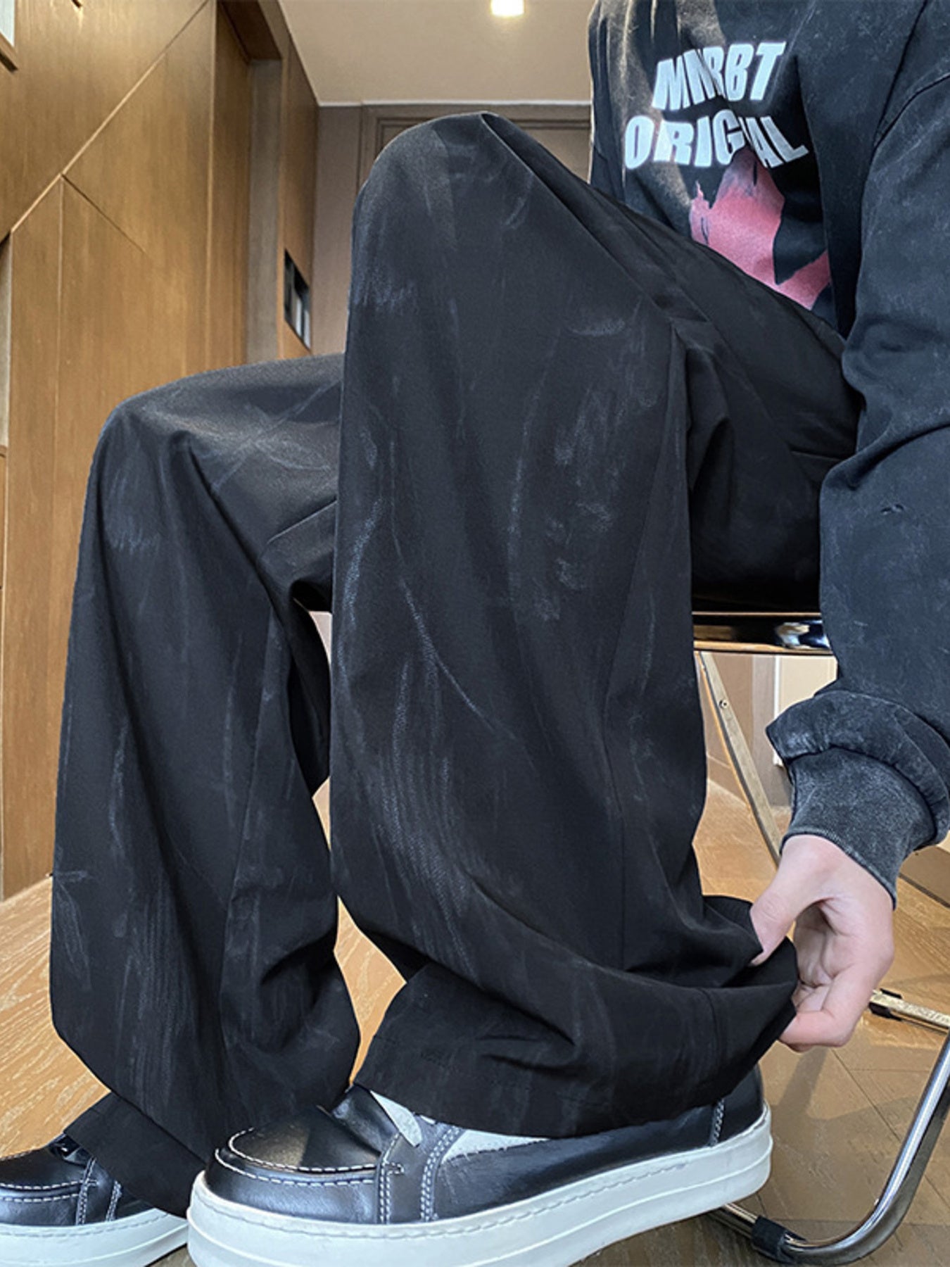 Men's black drawstring wide-leg trousers with a subtle textured pattern.