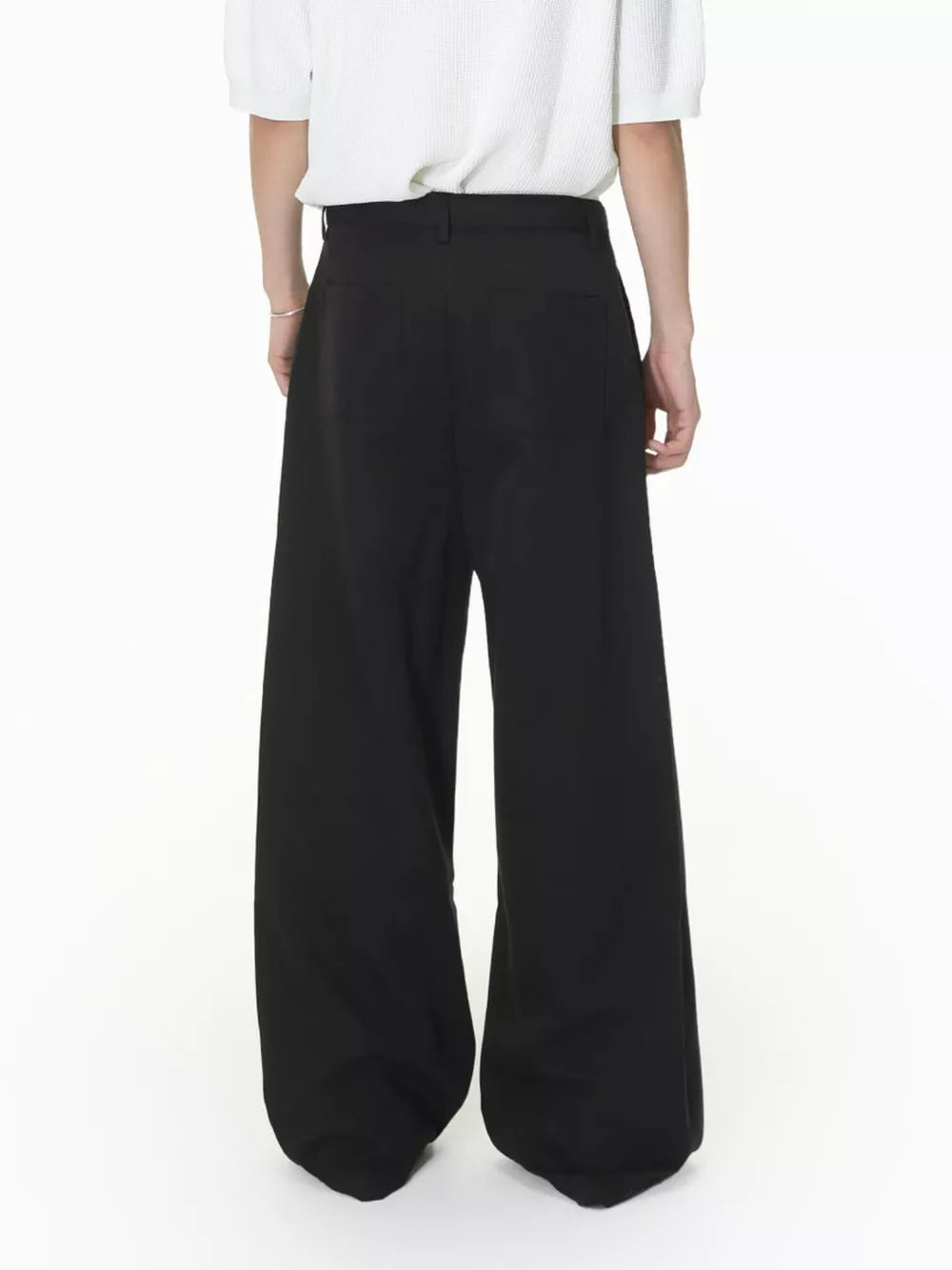 Black wide-leg pleated sweatpants with a belted waist and two back pockets.