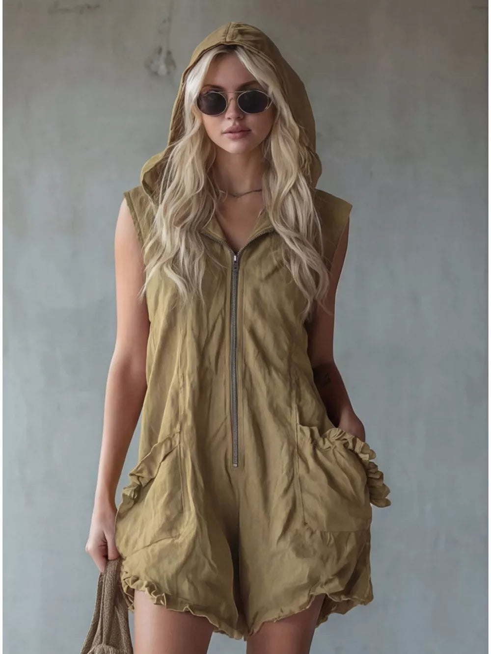 Khaki hooded sleeveless romper with ruffled pockets and zipper front.