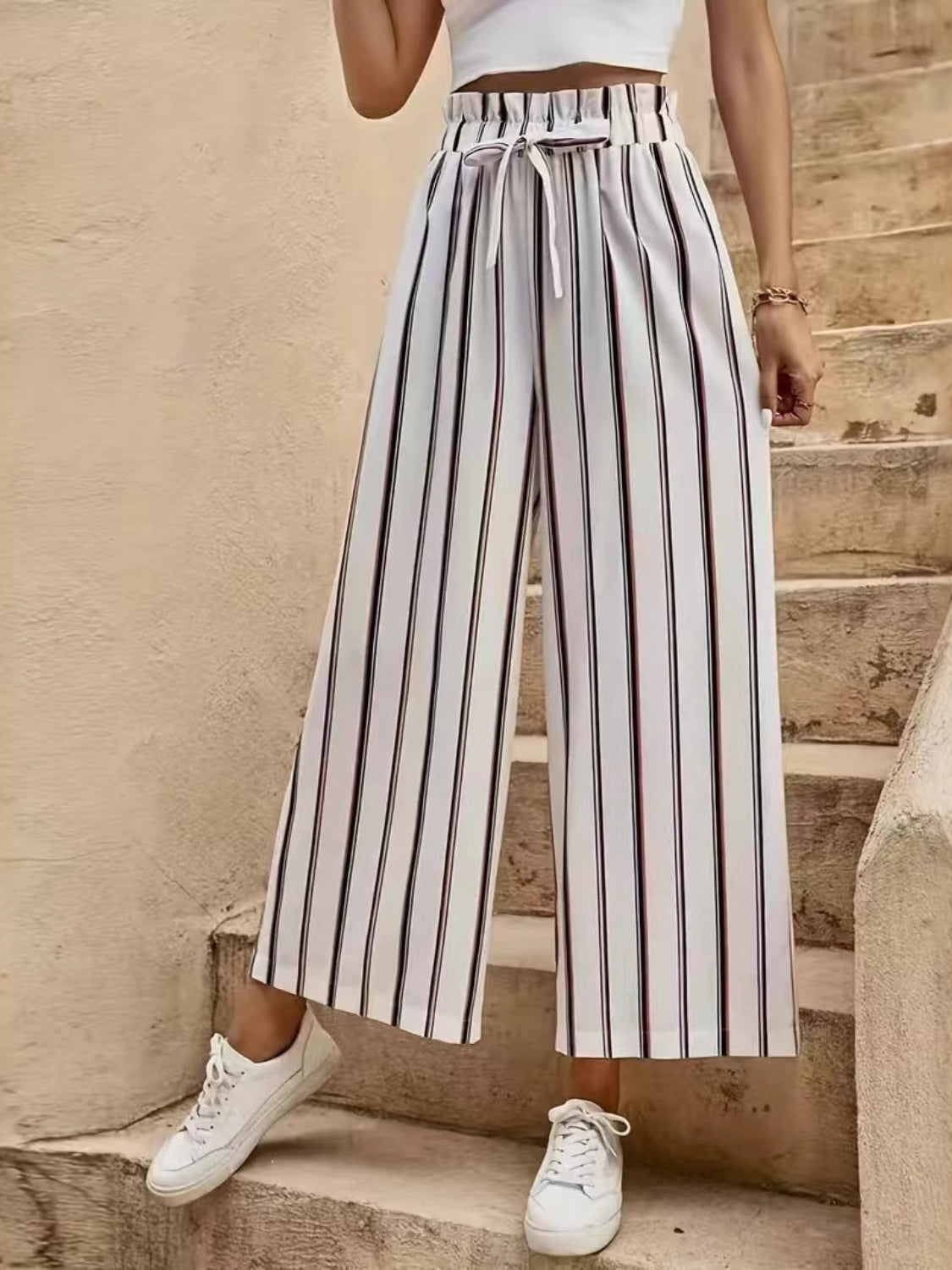 High-waisted palazzo pants with black and red vertical stripes and a drawstring waist.