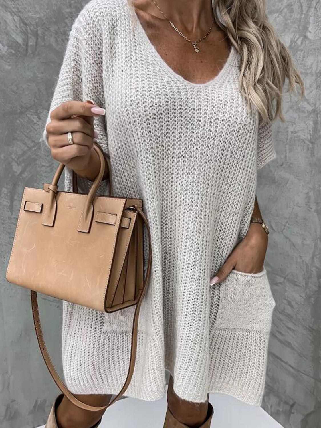Cream knit cocoon dress with v-neck, short sleeves, and patch pockets.