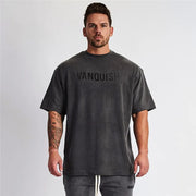 Oversized dark gray graphic tee with black VANQUISH text, crewneck, and short sleeves.
