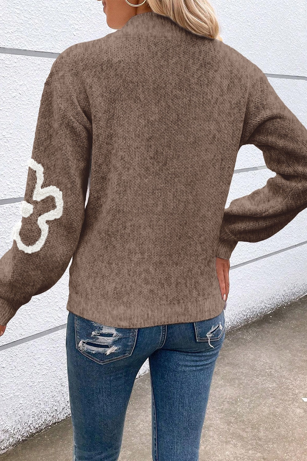 Brown knit pullover sweater with textured floral detail on sleeve and zip neck