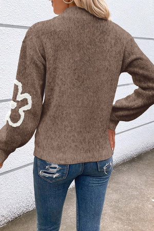 Brown knit pullover sweater with textured floral detail on sleeve and zip neck