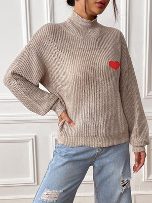 Khaki mock neck knit sweater with red heart appliqué and ribbed texture.
