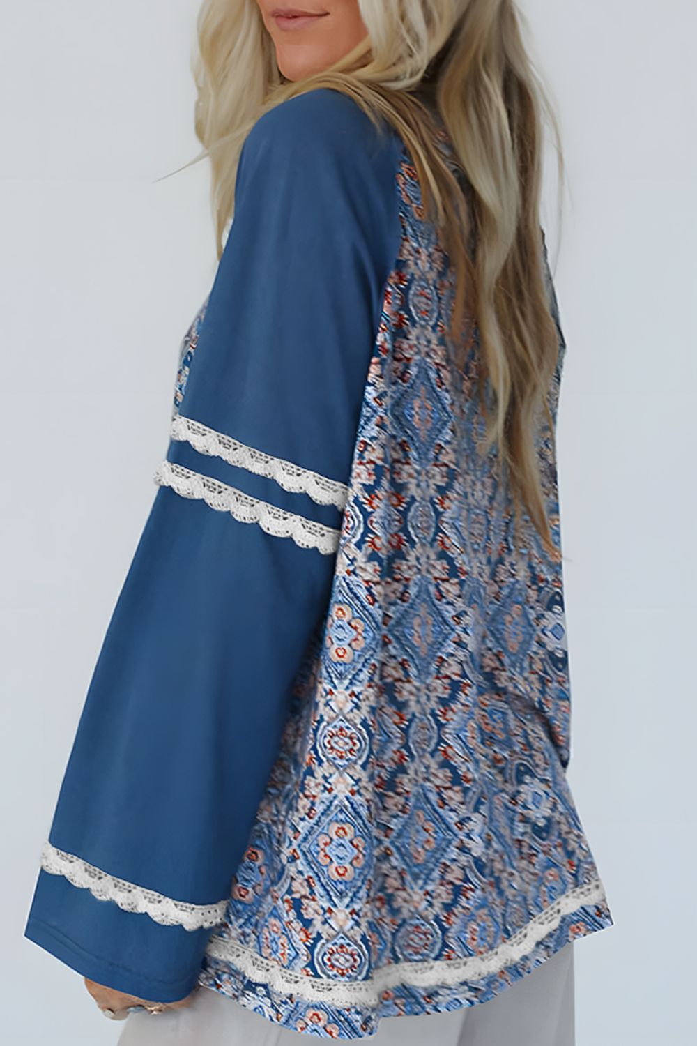 Dusty blue bohemian blouse with bell sleeves, lace trim, and a patterned back panel.