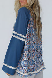 Dusty blue bohemian blouse with bell sleeves, lace trim, and a patterned back panel.