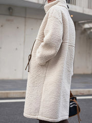Oversized beige sherpa overcoat with suede tie detail and pockets.