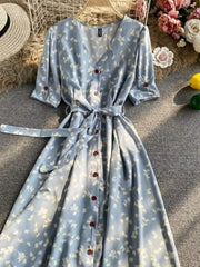 Light blue floral v-neck midi dress with button front, belted waist, and short sleeves.