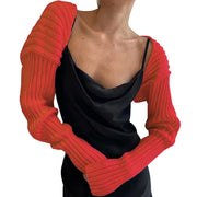 Orange ribbed knit shrug with extended sleeves and a cowl neck detail.