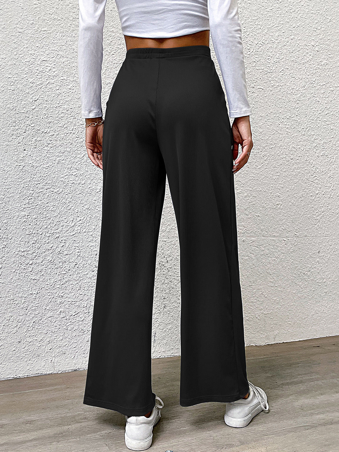 Black wide leg trousers with pleated front detail and a relaxed fit.