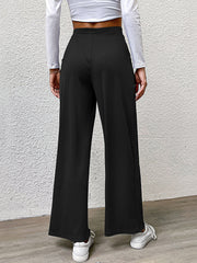 Black wide leg trousers with pleated front detail and a relaxed fit.