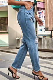 Light wash straight leg jeans with distressed details and frayed hem