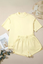 Yellow mock neck t-shirt and dolphin shorts set with dropped shoulders and elastic waistband.