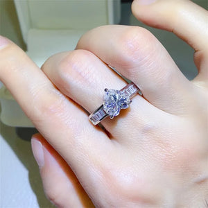 Silver ring with heart-cut moissanite and baguette accents