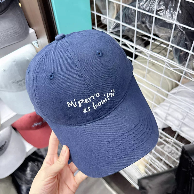 Navy blue baseball cap with white embroidered text "Mi perro es bonitá