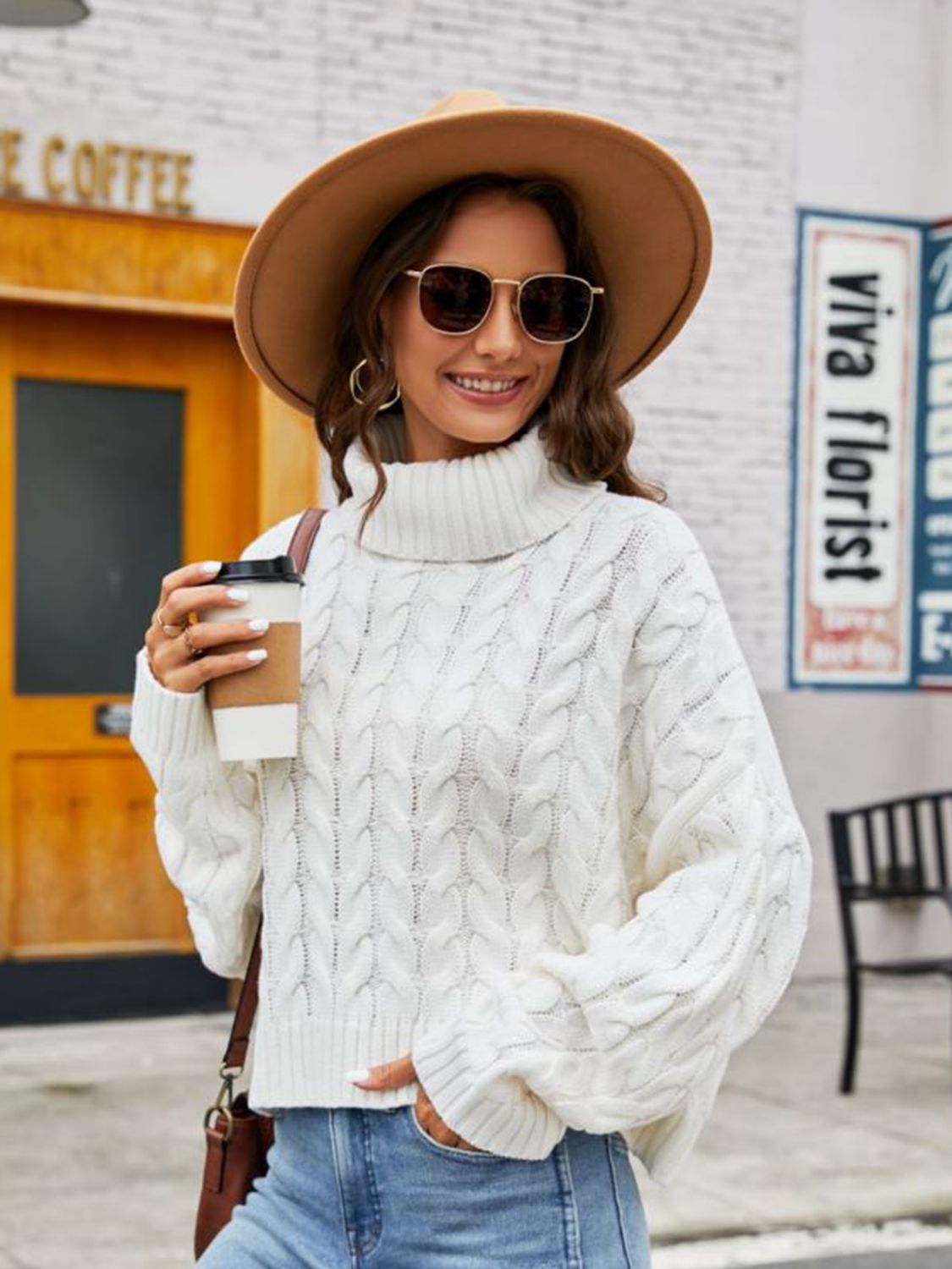 White cable-knit acrylic sweater with a chunky turtleneck and relaxed fit.