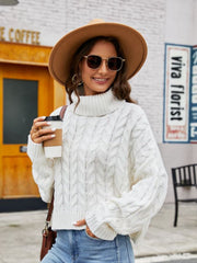 White cable-knit acrylic sweater with a chunky turtleneck and relaxed fit.